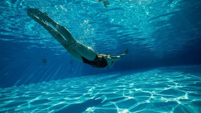 プールで潜っている女性