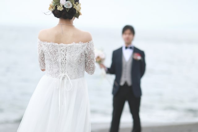 海辺で結婚式を挙げる男女